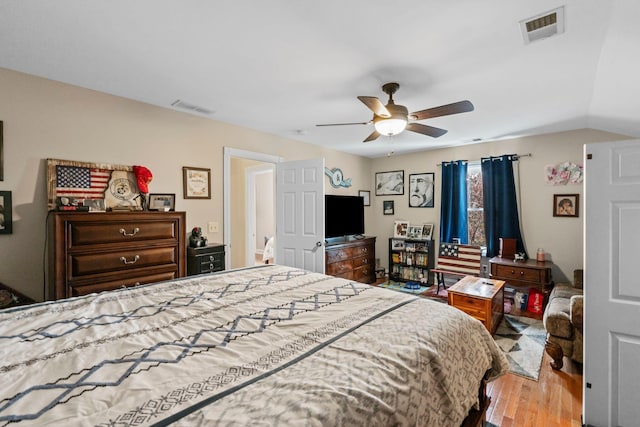 bedroom featuring visible vents, wood finished floors, ceiling fan, and vaulted ceiling