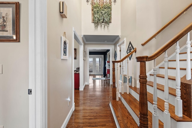 entryway featuring dark wood-style floors, a high ceiling, stairway, and baseboards
