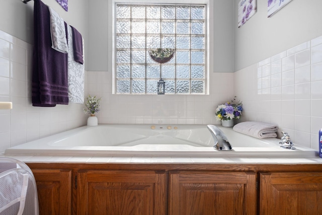 bathroom with a garden tub and tile walls
