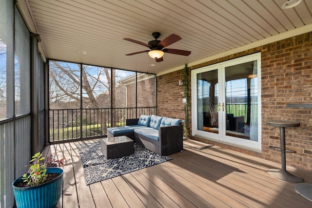 sunroom featuring a ceiling fan, french doors, and an outdoor living space