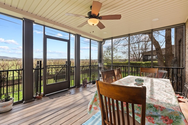 sunroom / solarium with outdoor dining space, ceiling fan, expansive windows, and hardwood / wood-style floors