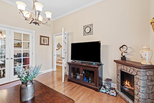 living room featuring visible vents, a notable chandelier, ornamental molding, wood finished floors, and french doors