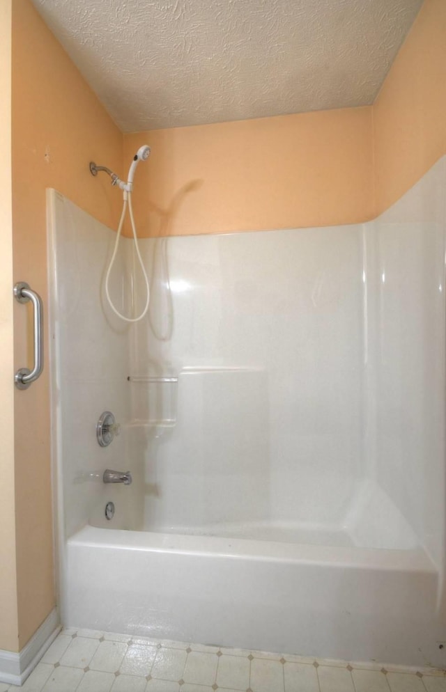 full bathroom with tile patterned floors, shower / tub combination, a textured ceiling, and baseboards