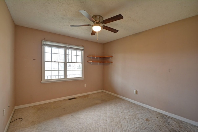spare room with visible vents, baseboards, ceiling fan, carpet, and a textured ceiling
