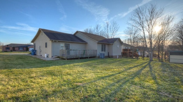 view of side of home with a yard, a deck, and central air condition unit