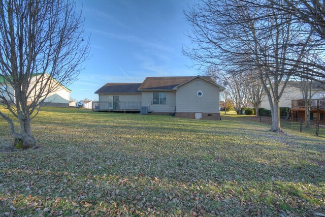 rear view of house with fence, a deck, and a lawn