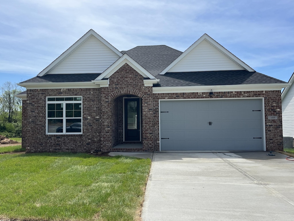 168 Bueno Xing, Georgetown, KY 40324 - view of front of property with brick siding, roof with shingles, driveway, an attached garage, and a front yard