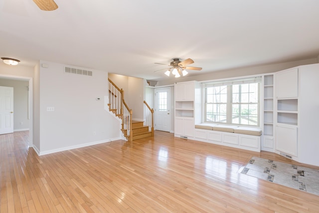 2692 Crab Orchard Rd, Lancaster, KY 40444 - unfurnished living room featuring light wood-type flooring, baseboards, visible vents, stairs, and ceiling fan