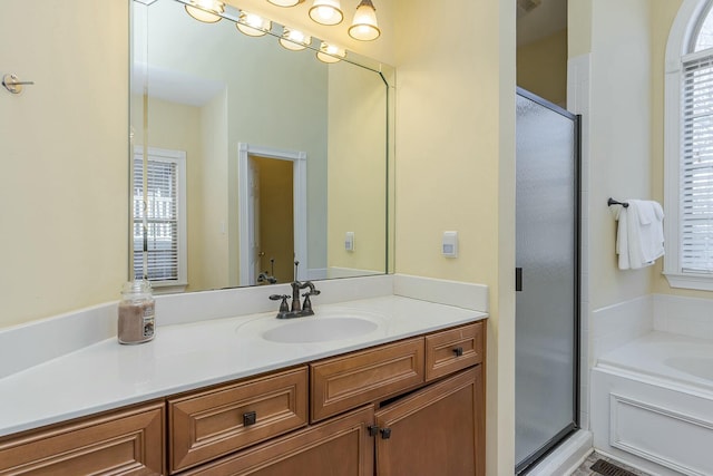 bathroom with vanity, a bath, and a stall shower