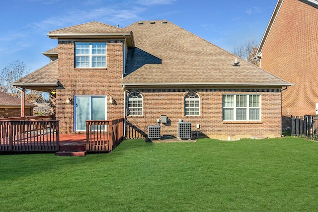 rear view of house featuring a yard, brick siding, and roof with shingles