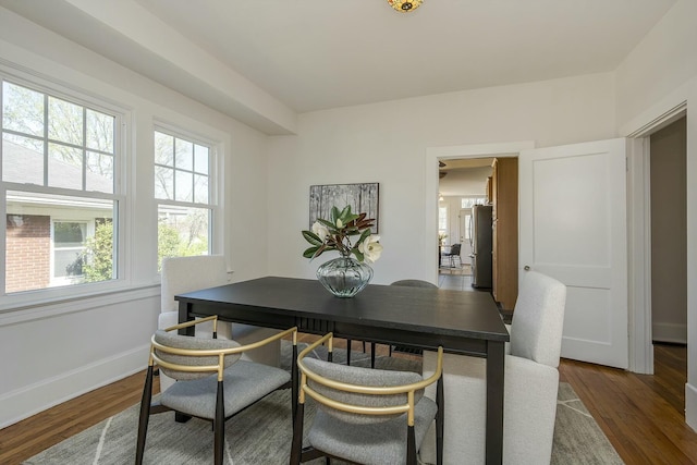dining space featuring wood finished floors and baseboards