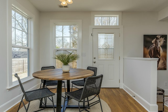 dining room featuring visible vents, a wealth of natural light, and wood finished floors