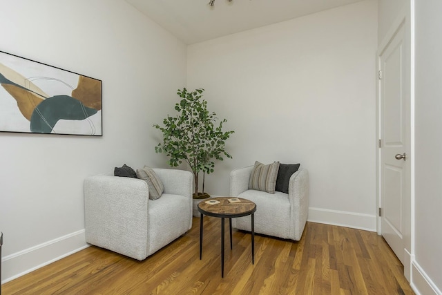 sitting room with wood finished floors and baseboards