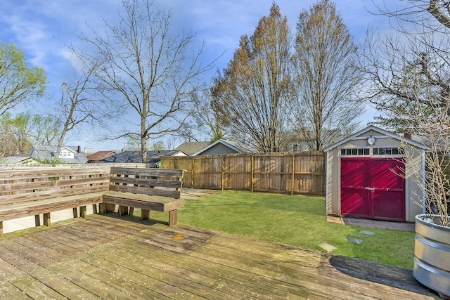 wooden deck with a storage shed, an outbuilding, a fenced backyard, and a lawn