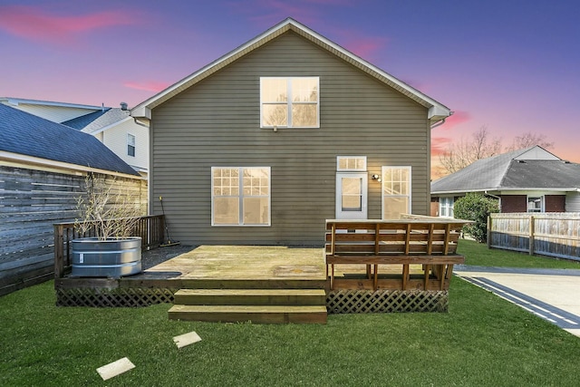 rear view of house with a yard, fence, and a wooden deck