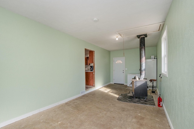 9 Blanche Ave, Williamstown, KY 41097 - spare room featuring a wood stove, unfinished concrete flooring, attic access, and baseboards