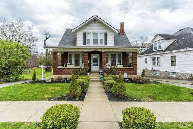 264 Houston Ave, Paris, KY 40361 - bungalow-style home featuring covered porch, brick siding, a chimney, and a front lawn