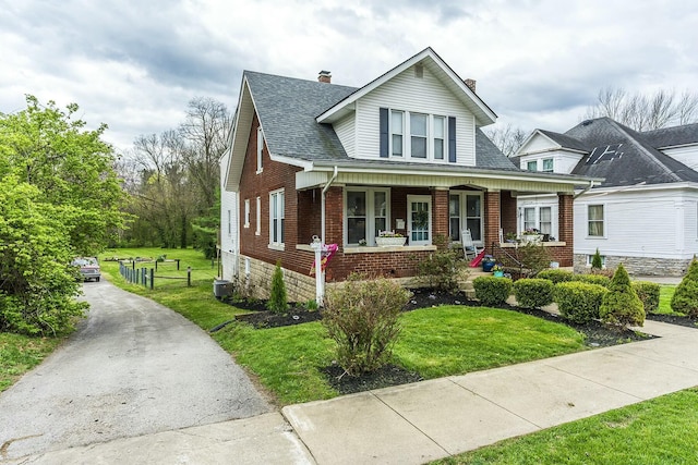 264 Houston Ave, Paris, KY 40361 - bungalow-style home featuring a front yard, roof with shingles, a chimney, brick siding, and a porch
