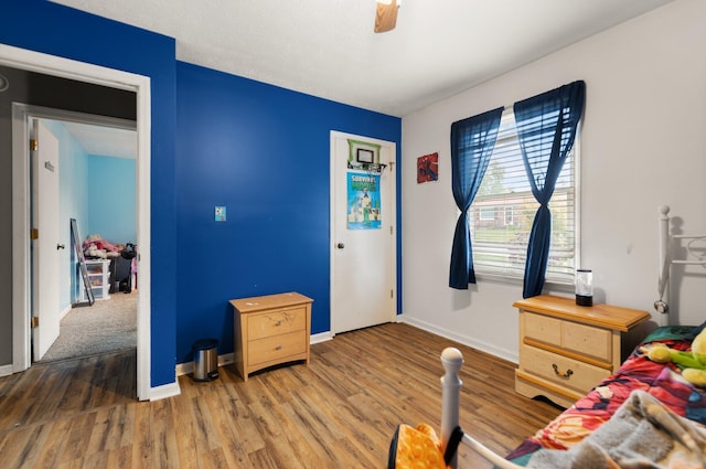 bedroom with baseboards, a ceiling fan, and wood finished floors