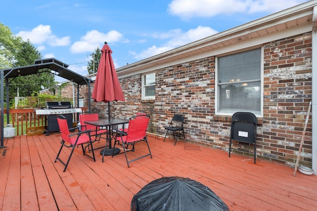 wooden terrace with a grill and outdoor dining area