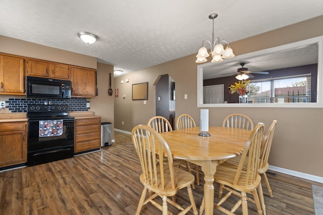 dining space featuring dark wood-type flooring, baseboards, a textured ceiling, and ceiling fan with notable chandelier