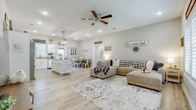 living area with recessed lighting, ceiling fan, plenty of natural light, and light wood-type flooring