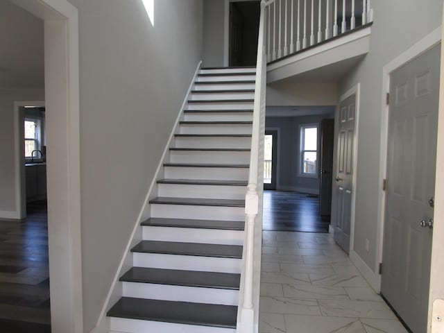 596 Overlook Dr, Lancaster, KY 40444 - staircase featuring marble look tiles, a towering ceiling, and baseboards