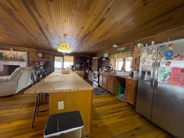 350 Wilderness Ln, Morehead, KY 40351 - kitchen featuring light countertops, appliances with stainless steel finishes, a breakfast bar, brown cabinetry, and hardwood / wood-style floors