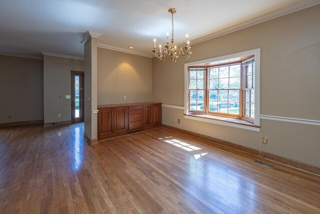 400 Redding Rd Unit 15, Lexington, KY 40517 - empty room with visible vents, baseboards, an inviting chandelier, ornamental molding, and wood finished floors