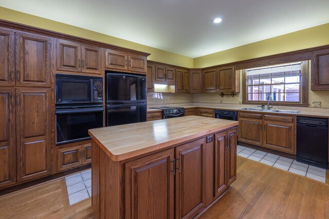 400 Redding Rd Unit 15, Lexington, KY 40517 - kitchen featuring black appliances, a kitchen island, light tile patterned flooring, a sink, and wood counters