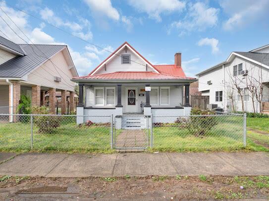 513 Washington Ave, Paintsville, KY 41240 - bungalow-style home with a front lawn, covered porch, metal roof, and a gate