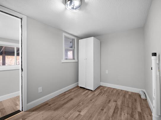 513 Washington Ave, Paintsville, KY 41240 - unfurnished bedroom featuring a textured ceiling, light wood finished floors, and baseboards