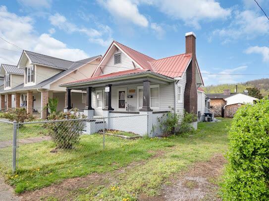 513 Washington Ave, Paintsville, KY 41240 - view of front of property featuring metal roof, fence private yard, a front lawn, and covered porch