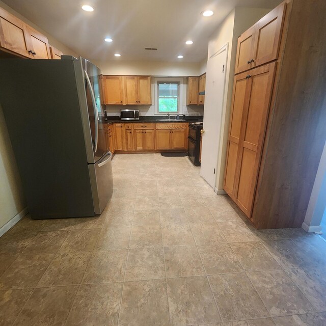 198 Hiawatha Trl, Georgetown, KY 40324 - kitchen featuring appliances with stainless steel finishes, a sink, dark countertops, recessed lighting, and brown cabinetry