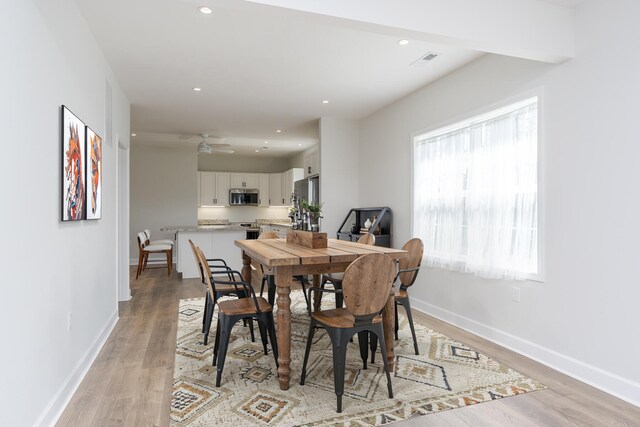 dining room featuring light wood-type flooring, baseboards, visible vents, and recessed lighting