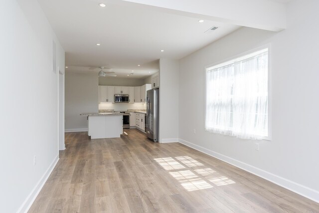 unfurnished living room featuring light wood-type flooring, baseboards, visible vents, and recessed lighting