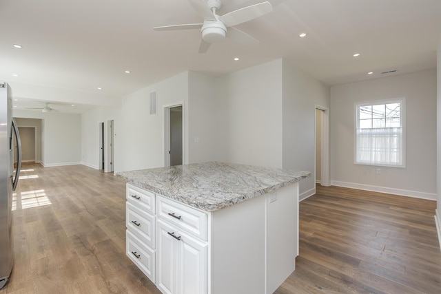 kitchen featuring open floor plan, a ceiling fan, and wood finished floors