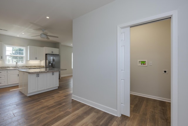 kitchen with stainless steel fridge with ice dispenser, a sink, dark wood-type flooring, a center island, and ceiling fan