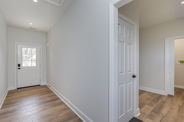 doorway to outside featuring baseboards, wood finished floors, and recessed lighting