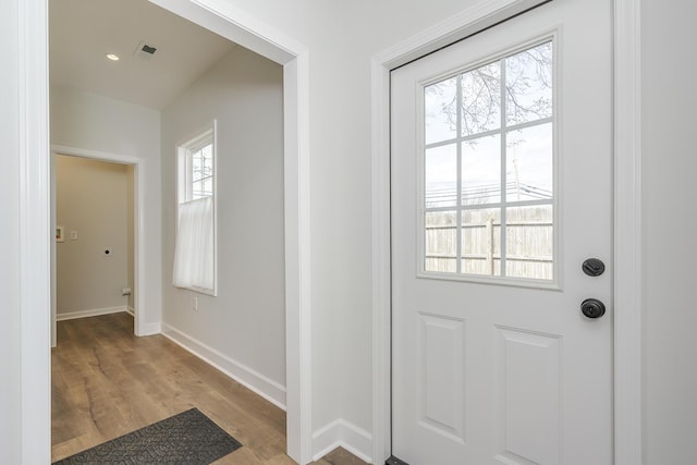 doorway featuring light wood-style floors, visible vents, and baseboards
