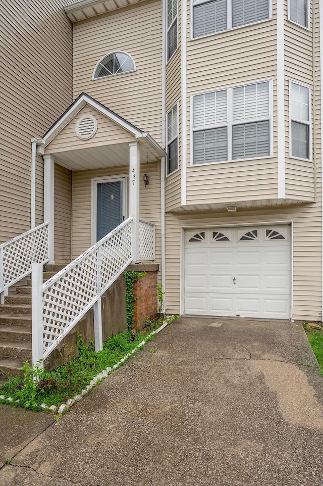 property entrance with driveway and an attached garage