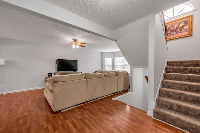 living room featuring a textured ceiling, wood finished floors, and ceiling fan