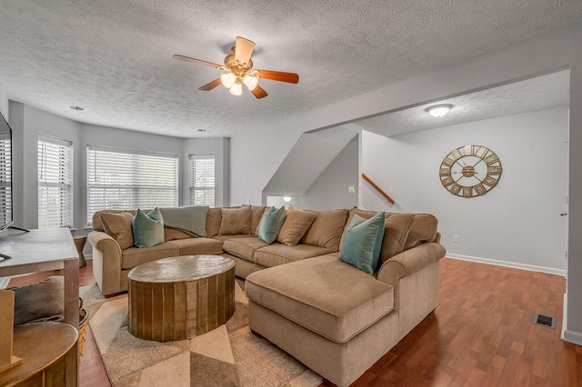 living room with visible vents, baseboards, a ceiling fan, a textured ceiling, and wood finished floors