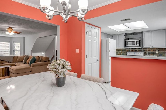 dining space featuring a chandelier, ornamental molding, and visible vents