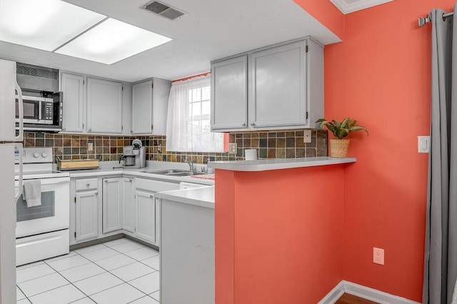 kitchen with visible vents, a sink, white electric stove, stainless steel microwave, and light tile patterned flooring