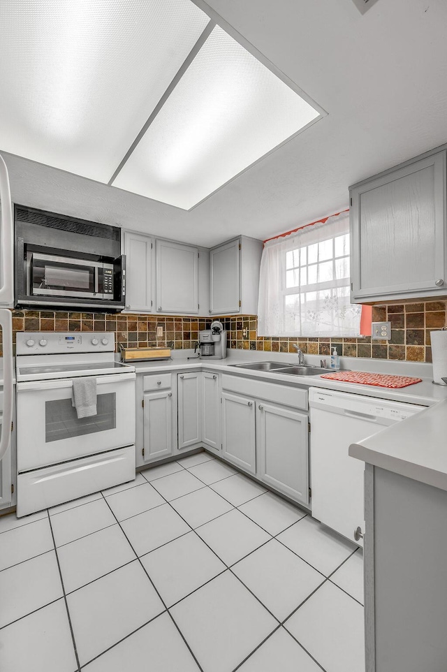 kitchen with backsplash, light countertops, white appliances, and light tile patterned floors