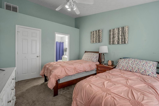 carpeted bedroom featuring a textured ceiling, ensuite bath, a ceiling fan, visible vents, and lofted ceiling