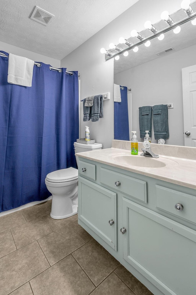 bathroom featuring visible vents, toilet, vanity, and a textured ceiling