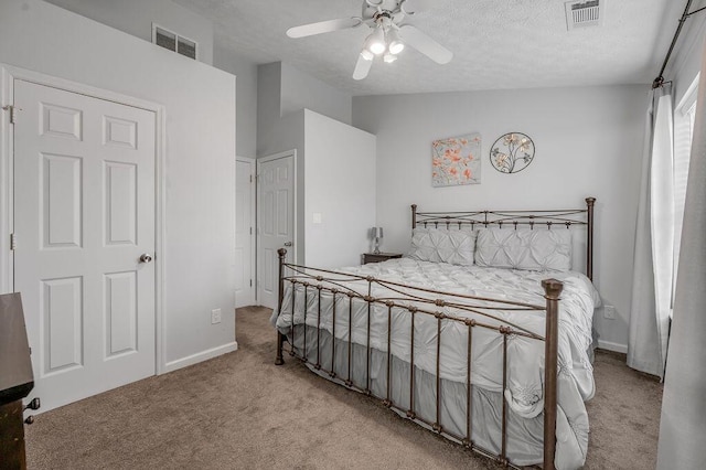 bedroom with a textured ceiling, lofted ceiling, visible vents, and carpet floors