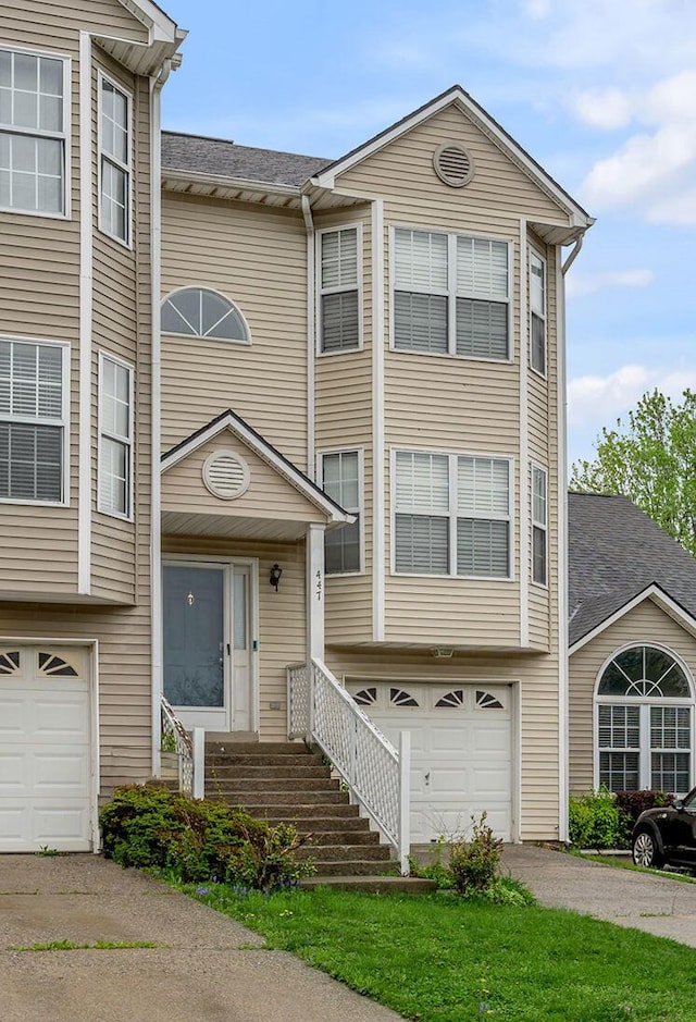 view of front of home featuring driveway, a shingled roof, and a garage